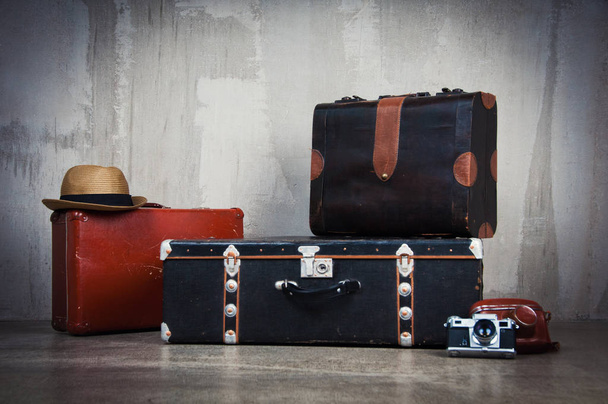 Background stack of old shabby suitcases and the camera. - Valokuva, kuva