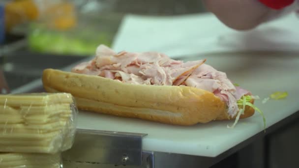 Submarine deli sandwich being made and sliced - Felvétel, videó