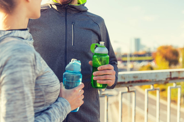close up of couple with water bottles outdoors - Foto, Bild