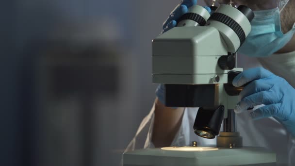 Scientist adjusts microscope to see cell molecular compound, microbiology - Filmagem, Vídeo
