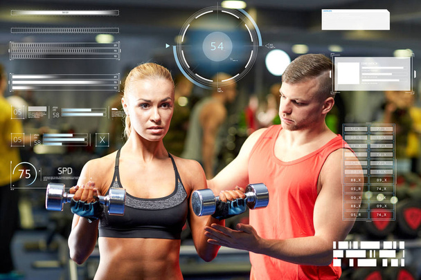 young couple with dumbbells flexing muscles in gym - Fotoğraf, Görsel