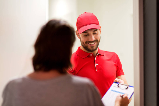deliveryman with clipboard at customer home - Foto, immagini