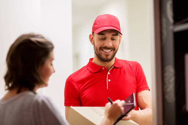 delivery man with box and tablet pc at customer - Фото, зображення