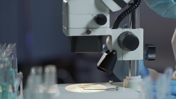 Research analyst adjusting microscope to detect red and white blood cells - Filmagem, Vídeo