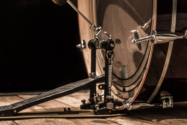 κρουστό όργανο, μπάσο τύμπανο με πεντάλ πάνω σε ξύλινες σανίδες με μαύρο φόντο - Φωτογραφία, εικόνα