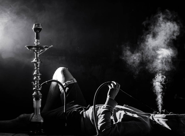 mężczyzna pali fajki na czarnym tle, piękne oświetlenie - Zdjęcie, obraz