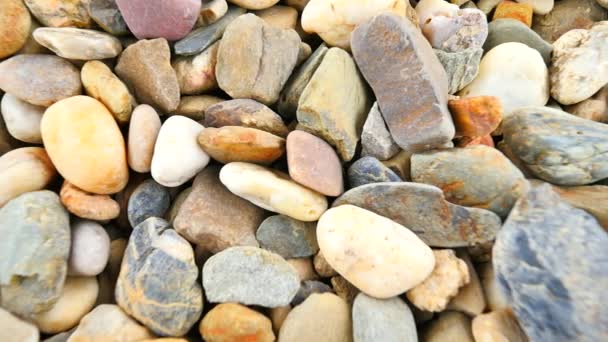 Oude stenen bestrating van natuurlijke grind droog afgeronde stenen, traditionele bouwmaterialen, kleine kleurrijke steentjes. Camera beweegt close-up op grond.  - Video