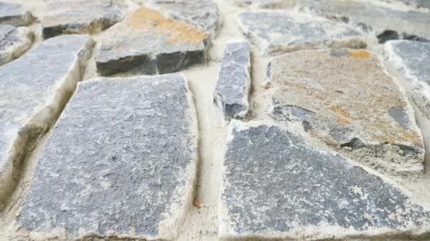 Οικοδόμηση τείχους που χτίστηκε από σπασμένα επίπεδες πέτρες. Παλιό πέτρινο τοίχο από φύση υλικών και σκυροδέματος, σπασμένα marl πέτρες, παραδοσιακών δομικών υλικών.  - Πλάνα, βίντεο