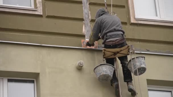 El hombre trabaja en obras de gran altura revestimiento, enlucido de la casa
 - Metraje, vídeo