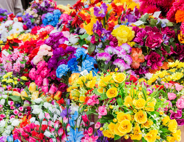 Számos mesterséges virágok. A virágok színes háttérrel - Fotó, kép