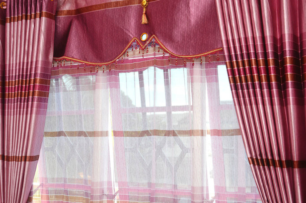 cortina de seda roja en la ventana
 - Foto, imagen
