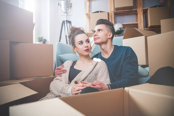 Couple moving in new home and relaxing on floor after unpacking boxes - Photo, Image