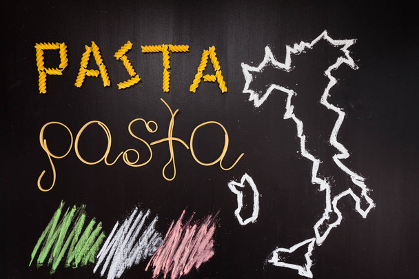 Words pasta made of cooked spaghetti and dry pasta on the black background with frame of country Italy written by chalk and flag of Italy - Φωτογραφία, εικόνα
