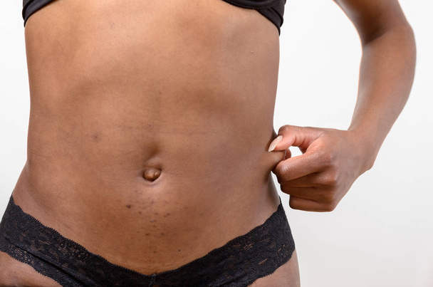 Ajuste tonificado joven mujer mostrando que ella no tiene grasa
 - Foto, Imagen