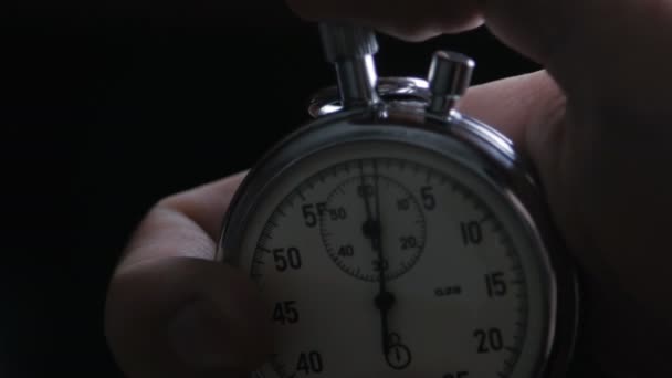 Una persona che mette in moto un cronometro su sfondo nero
 - Filmati, video