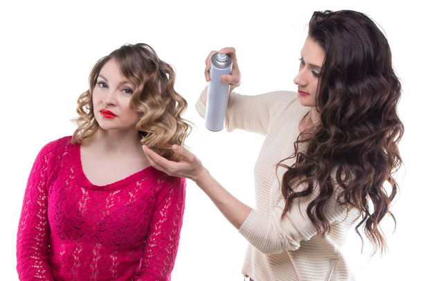 Kampaaja hiuslakkaa ja asiakas nainen
 - Valokuva, kuva