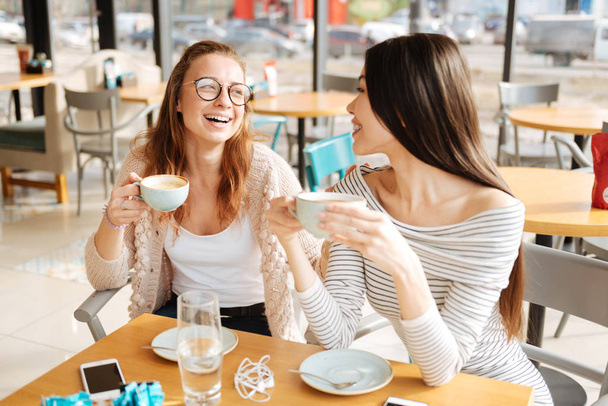 Joyful female friends talkign in the cafe - Фото, зображення
