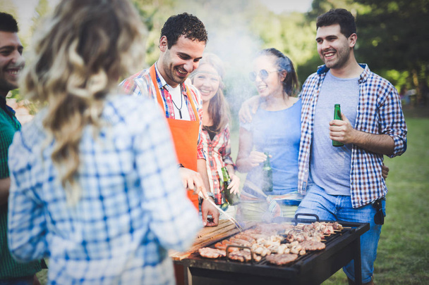 Happy friends enjoying barbecue party - Photo, Image
