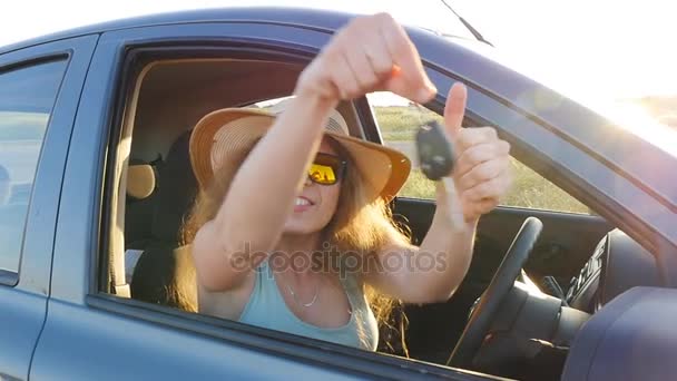 Kobieta uśmiechając się, pokazuje nowe kluczyki do samochodu - Materiał filmowy, wideo