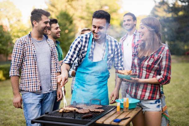 Happy friends enjoying barbecue party - Fotó, kép