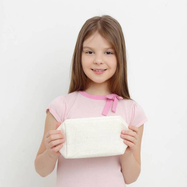 Caucasian little girl and cosmetic bag - 写真・画像