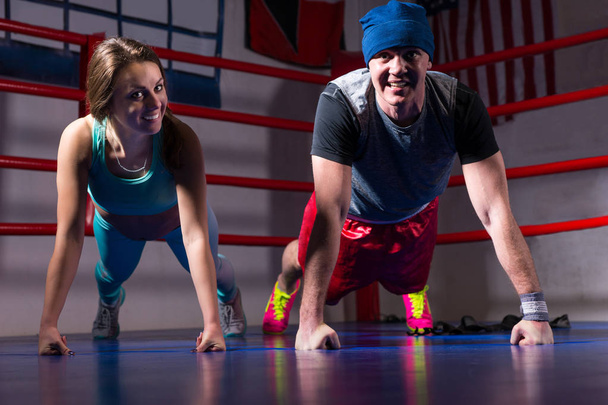 Jovem casal desportivo em sportswear fazendo push-up
 - Foto, Imagem