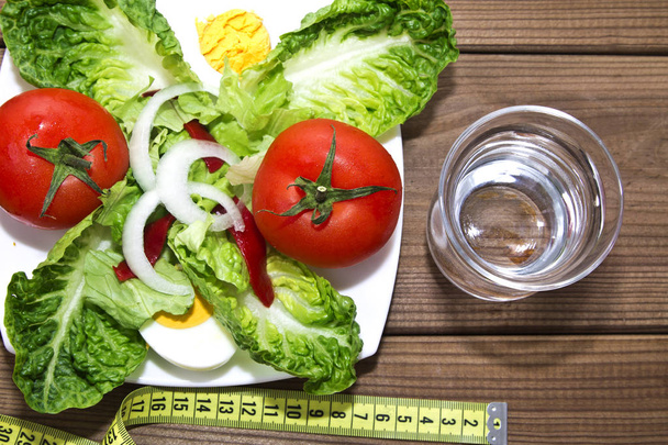 Salad with glass of water and tape measure - Foto, imagen