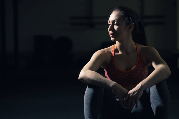 Woman sitting in gym - Фото, изображение