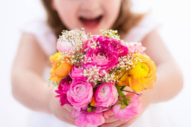 Little girl with flower bouquet - Фото, изображение