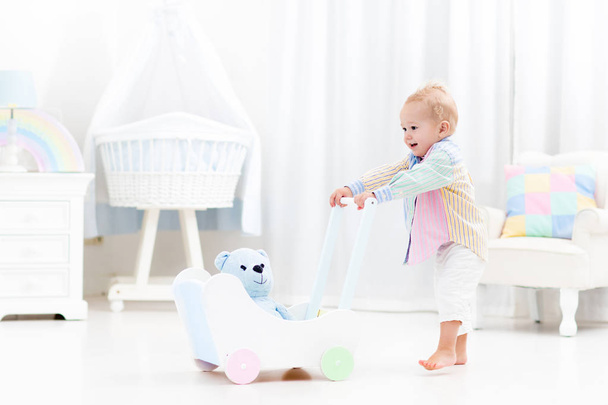 Baby with push walker in white bedroom - Photo, Image
