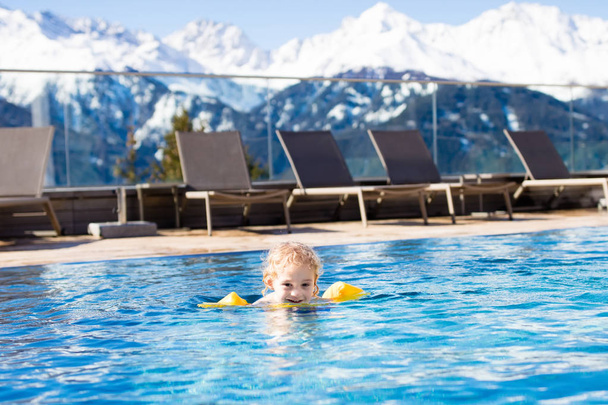 Ребенок в открытом бассейне альпийского курорта
 - Фото, изображение