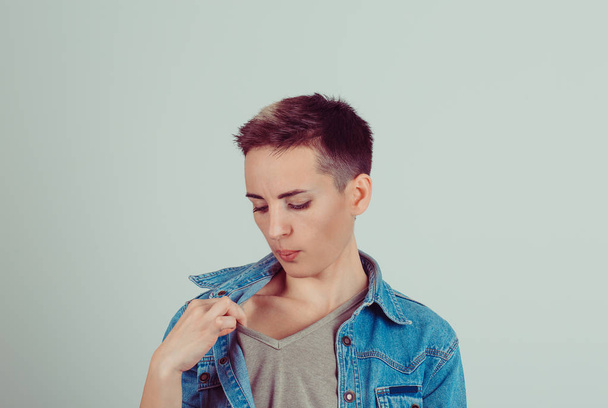  teenager girl opening t-shirt to vent it's hot in here blowing air unpleasant awkward situation embarrassment isolated grey green wall  - Fotoğraf, Görsel