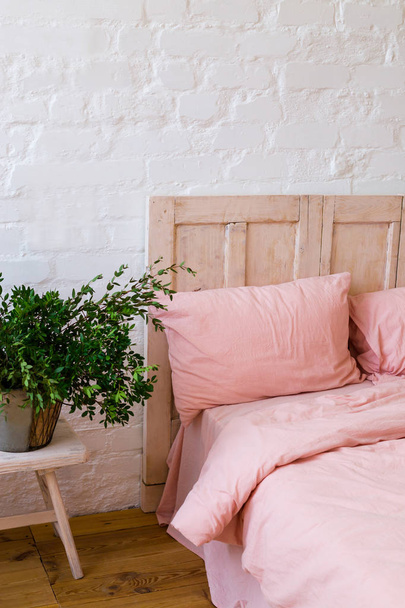 Cama vacía con almohadas rosas y funda rosa en el dormitorio
.  - Foto, imagen