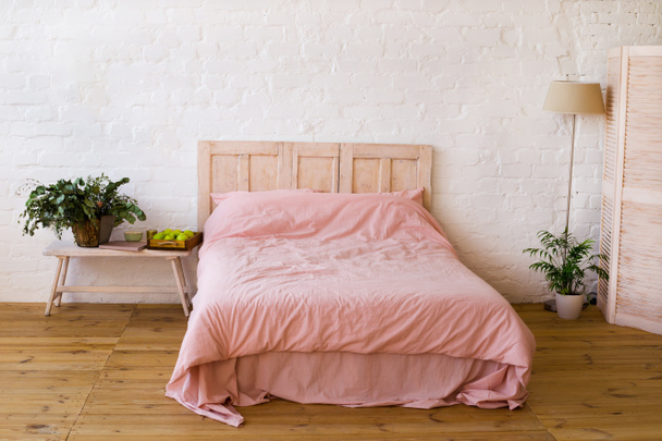 Lit vide avec oreillers roses et couverture rose dans la chambre
. - Photo, image