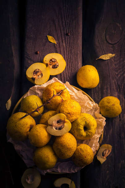 Fruits twigs quince wooden table - Foto, Imagen