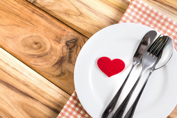 red heart shape with White empty plate with fork and spoon on wo - Foto, Imagen