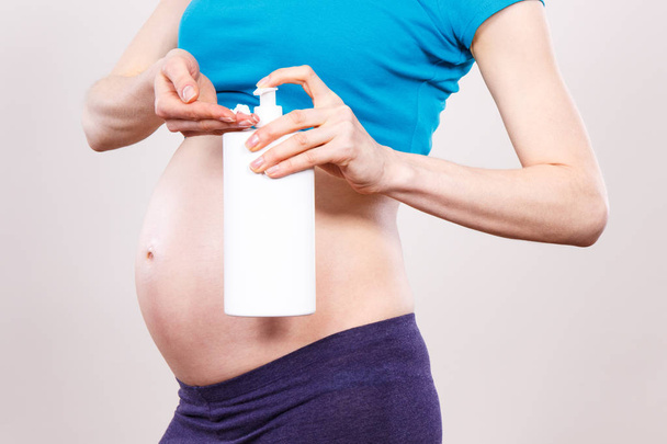 Pregnant woman applying moisturizing lotion on belly, avoid stretch marks - Fotografie, Obrázek