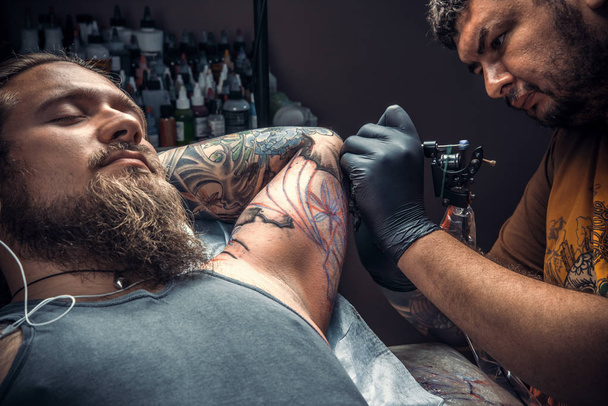 Tatuaje artista haciendo tatuaje en estudio
 - Foto, Imagen