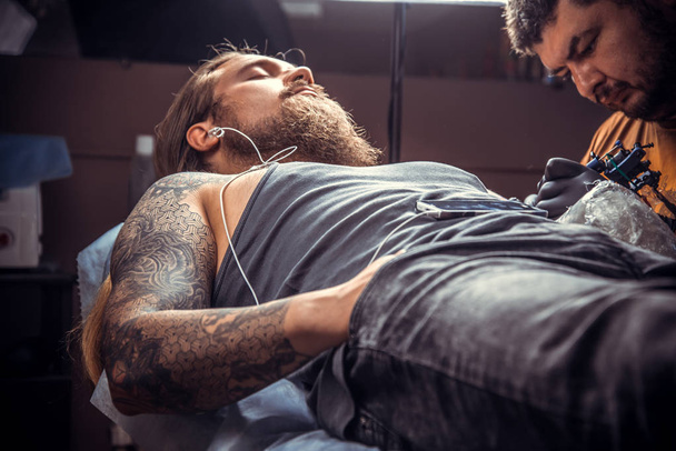 Tatuaje de trabajo profesional del tatuador en el estudio. / Tatuaje profesional trabaja en el salón
. - Foto, Imagen