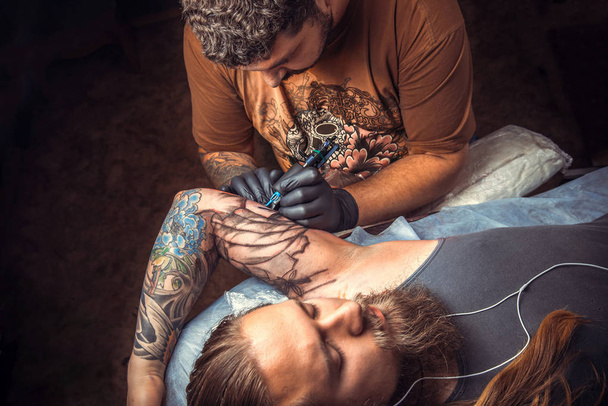 Professional tattooist create tattoo in studio - Foto, imagen
