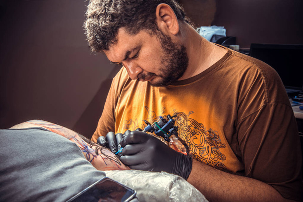 Mester működő tetoválás, tetováló szalon szakmai tattooist mutatja a folyamat, hogy egy tetoválás stúdió /. - Fotó, kép