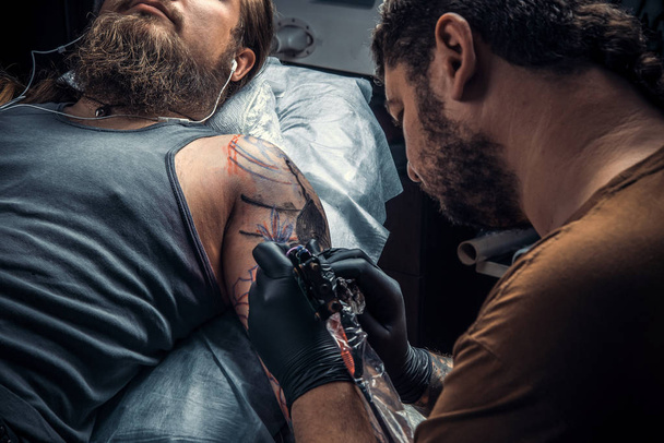 Szakmai tattooer hozzon létre tetováló szalon. / szakmai tattooist mutatja a folyamat, hogy egy tetoválás, tetováló szalon. - Fotó, kép
