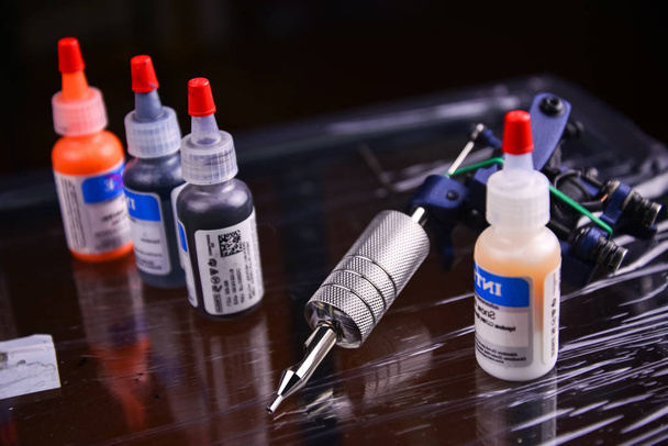 tattoo gun and vials with different colored ink for tattoos - Photo, Image