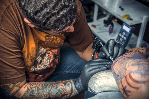 Tatuaje artista haciendo un tatuaje en el estudio
 - Foto, Imagen