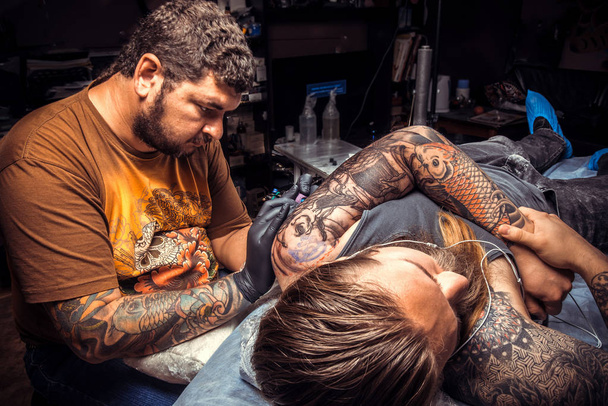 Maestro de tatuajes posando en salón de tatuajes. / tatuador profesional hace fotos de tatuajes en estudio de tatuajes
. - Foto, Imagen