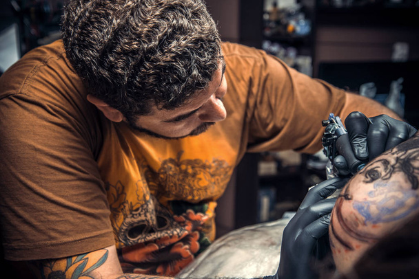Tetováló mester pózol studio. / szakmai tattooist működik, tetoválás, tetováló szalon. - Fotó, kép