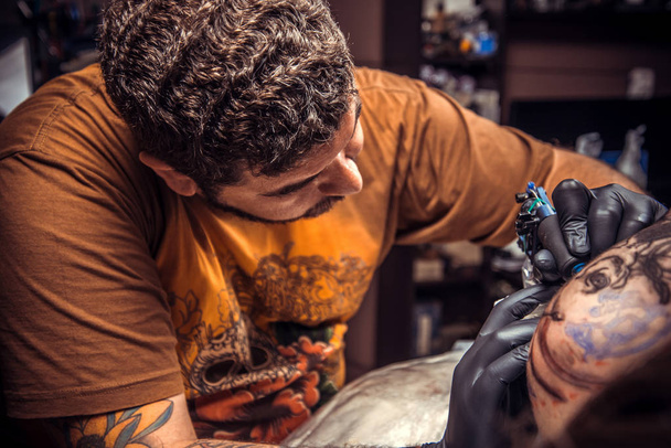 Specialista del tatuaggio che fa tatuaggio in studio del tatuaggio. / Tatuaggio professionale crea tatuaggio in studio del tatuaggio
. - Foto, immagini