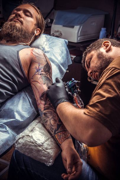 Mester munkahelyi studio. / szakmai tattooist mutatja a folyamat, hogy egy tetoválás, tetováló szalon. - Fotó, kép