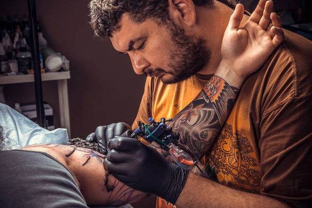 Tattooer trabaja en salón de tatuajes
 - Foto, Imagen