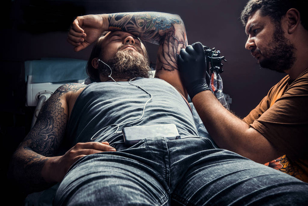 Tatuagem fazendo tatuagem em estúdio
 - Foto, Imagem
